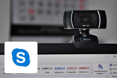 Webcam hardware rested on top a monitor with Skype logo